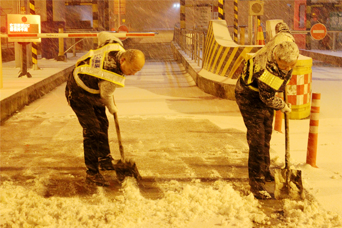 阜阳处阜新路收费站党支部书记曹永恒正在清除道口积雪（图右）.jpg